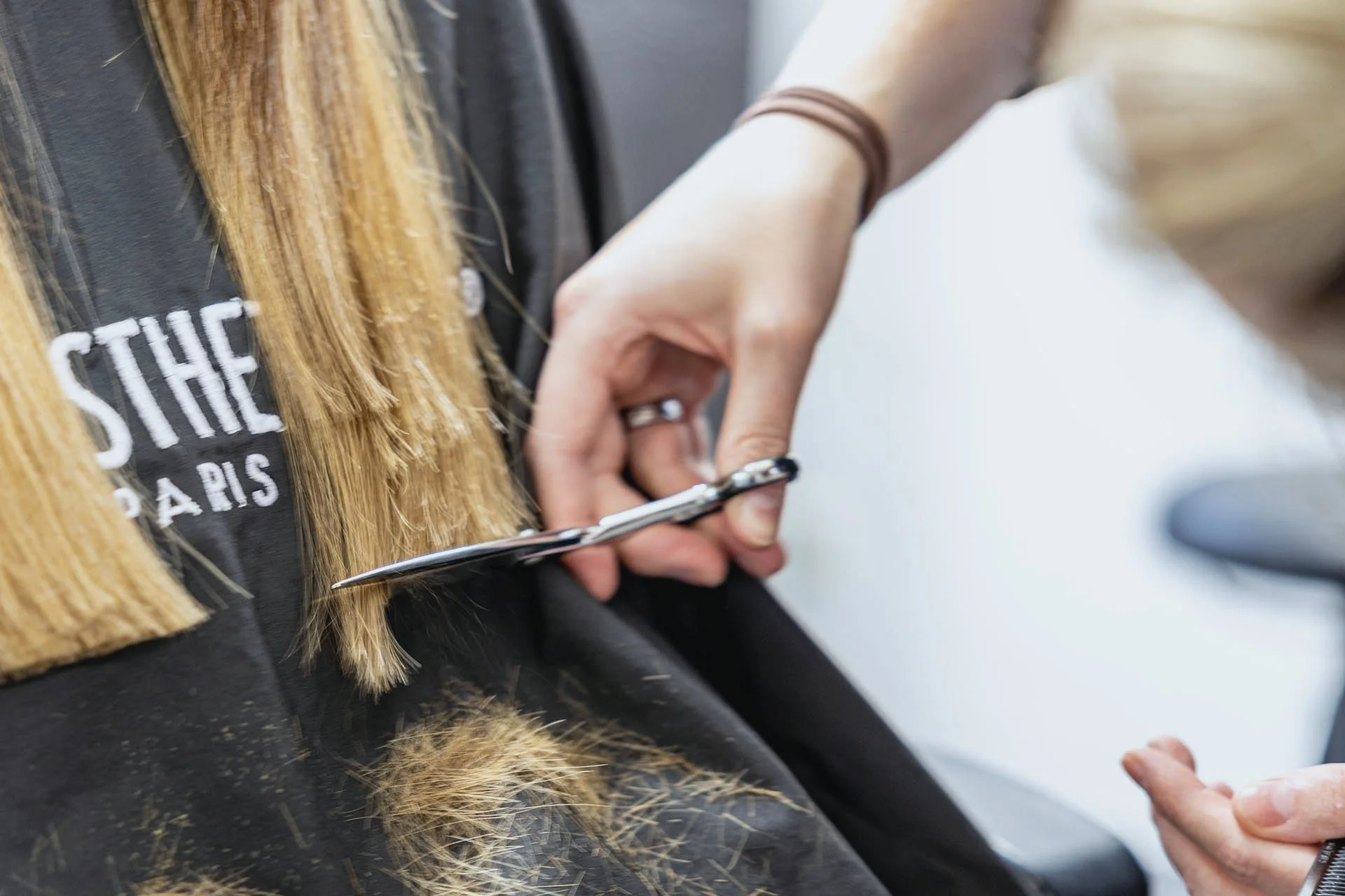 Hairstylistin mit Schere bei präziser Schnittarbeit.