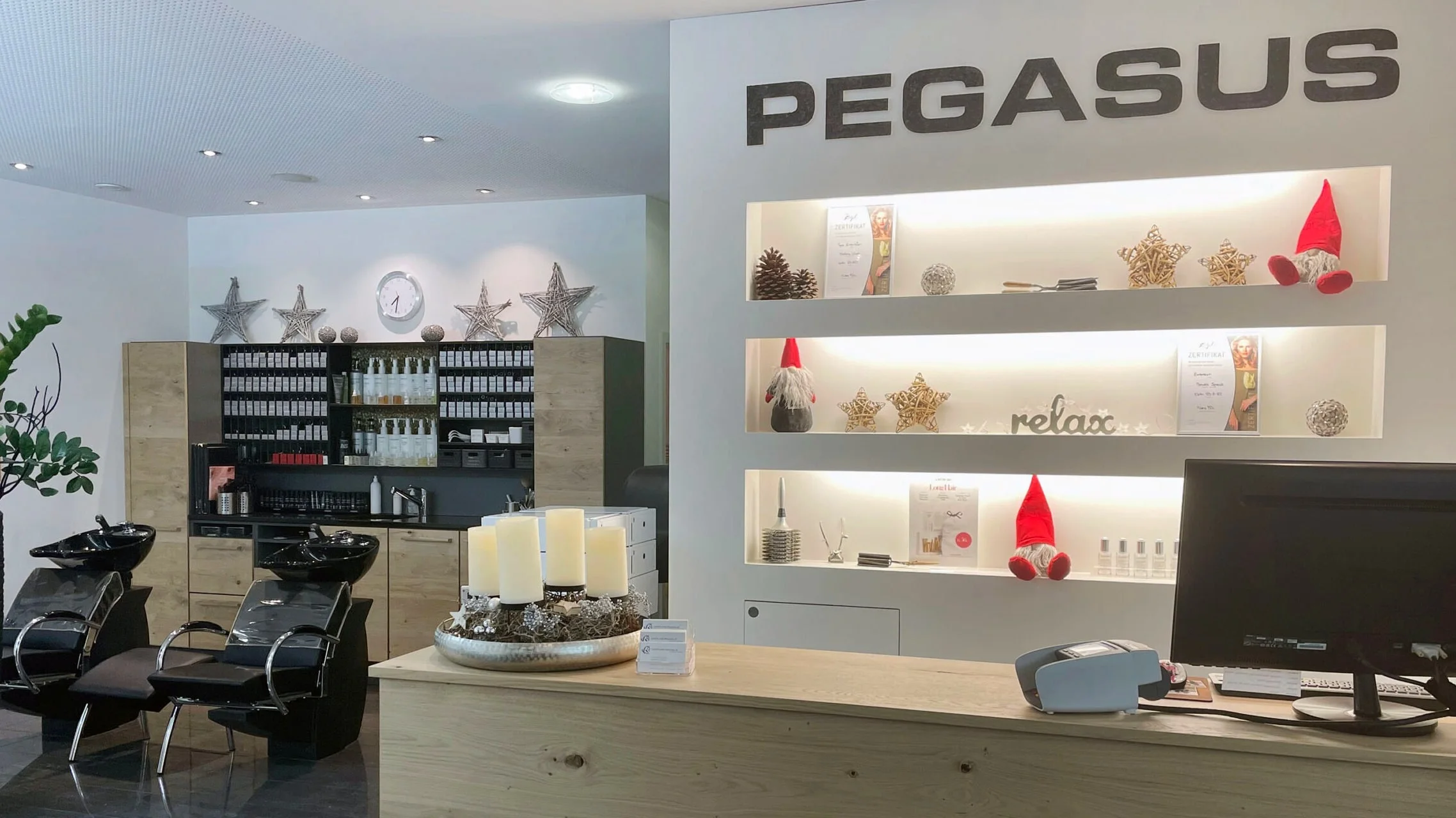 Innenansicht des Salons PEGASUS Hairdesign in Einsiedeln mit warmem Licht.