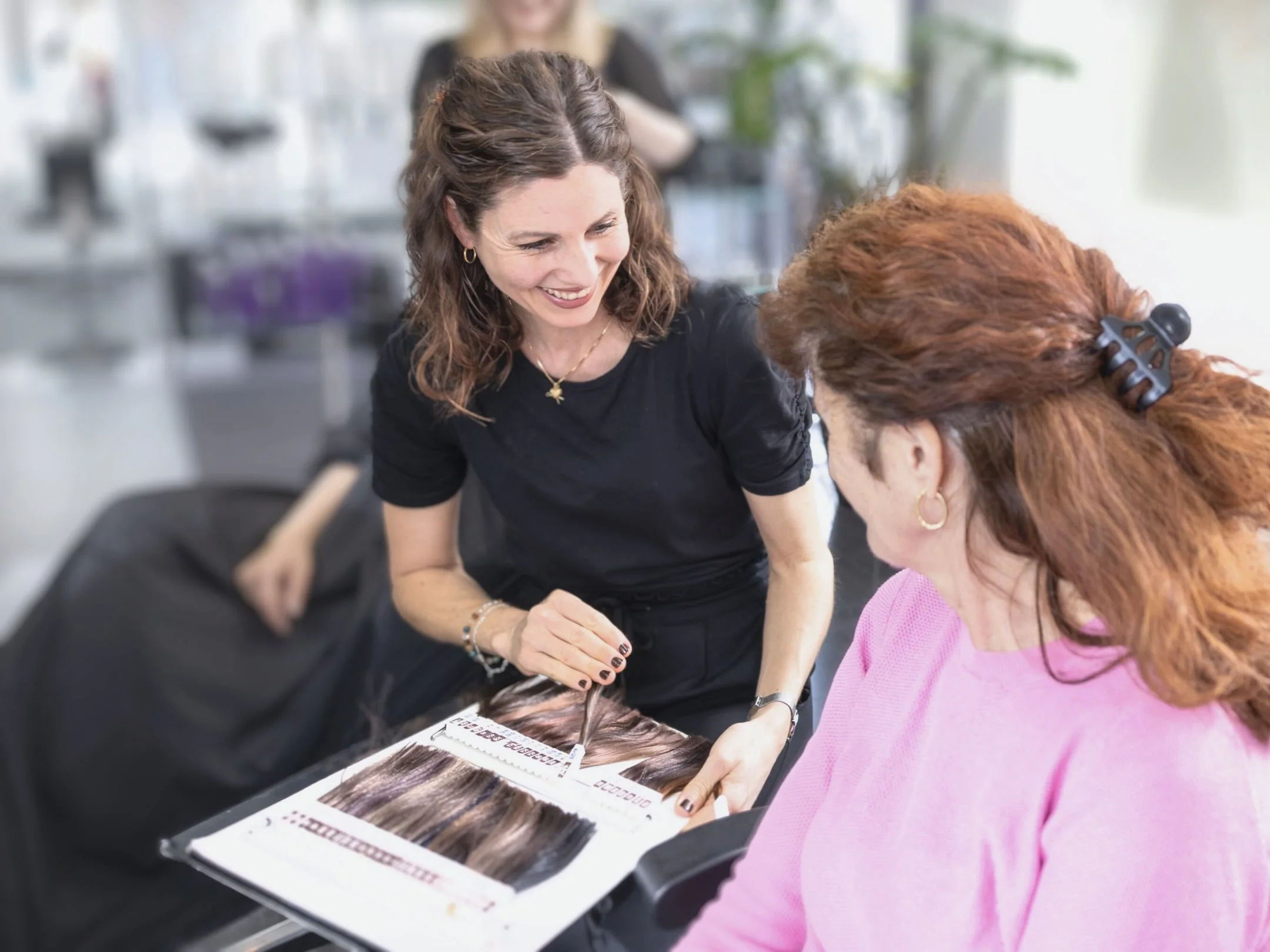 Beratung mit Haarfarbmustern im Coiffeursalon.